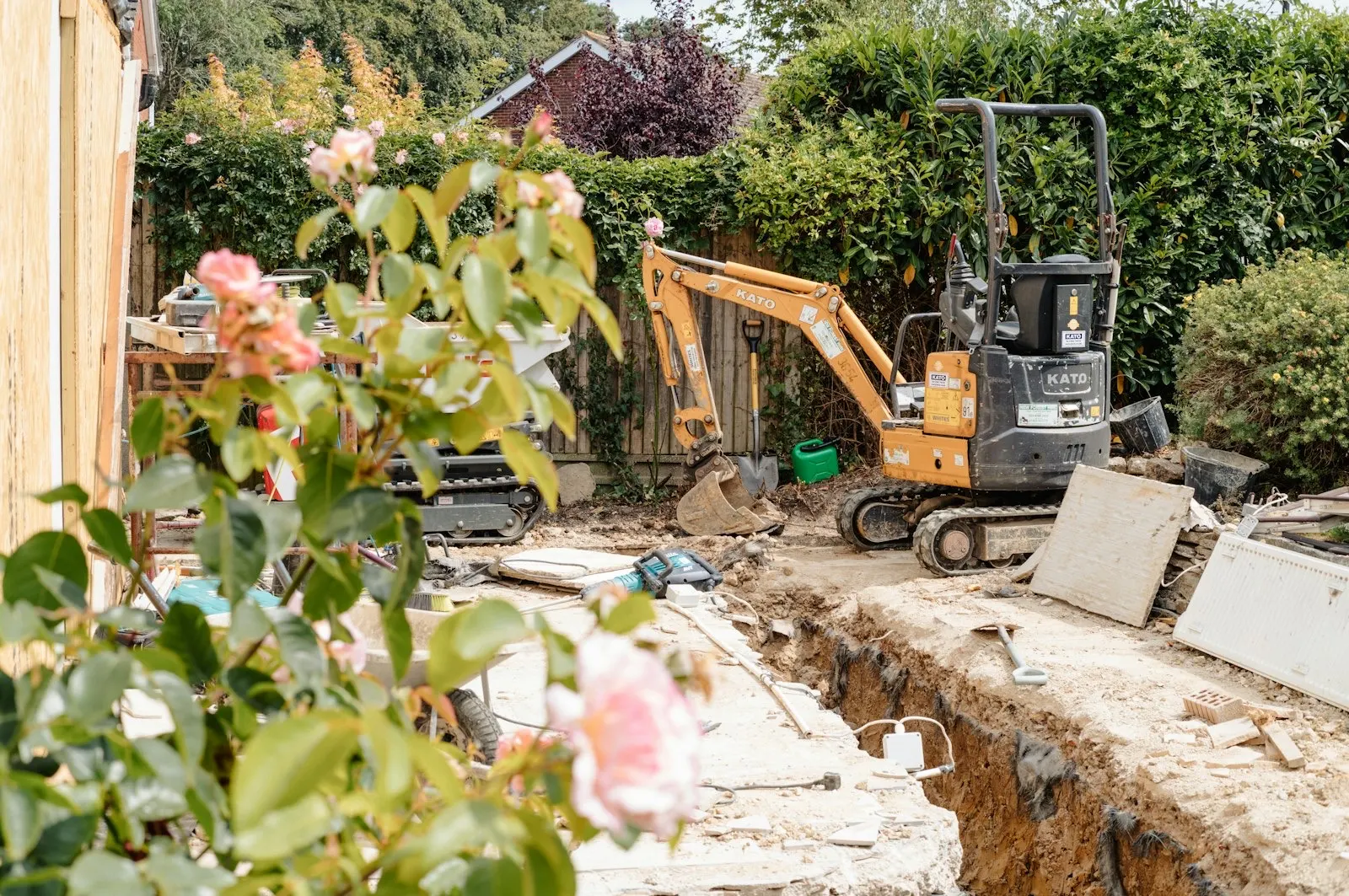 Excavator working on a garden drainage repair