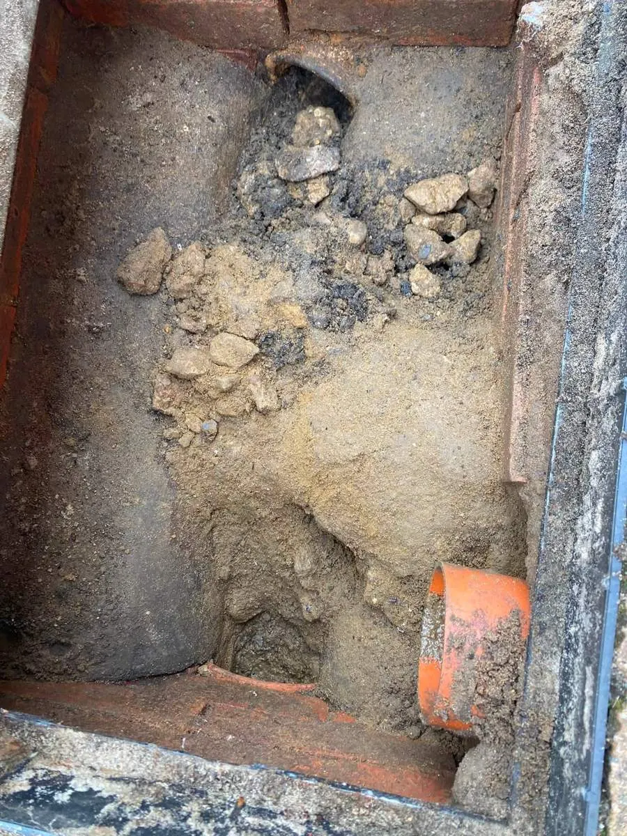 Sand and stone dumped in a manhole